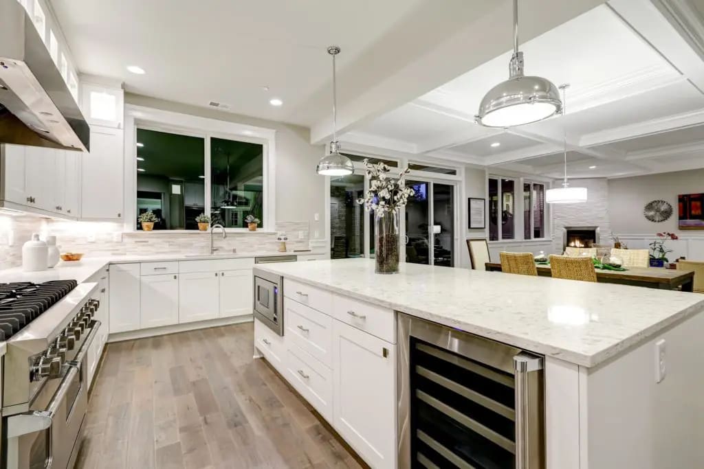 Gourmet kitchen features white shaker cabinets with marble countertops stone subway tile backsplash and a gorgeous kitchen island Northwest USA